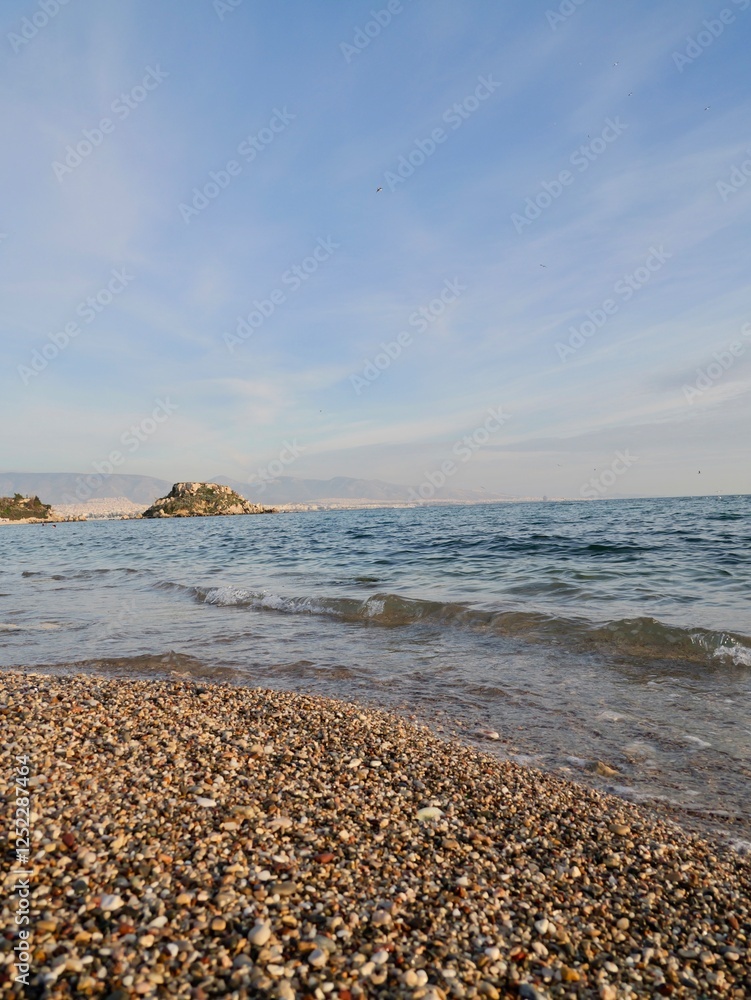 View of the seaside and Hymettus or Hymettos, a mountain range in the Athens area of Attica, from the Votsalakia beach, Piraeus, Greece View of the seaside and Hymettus or Hymettos, a mountain range in the Athens area of Attica, from the Votsalakia beach, Piraeus, Greece