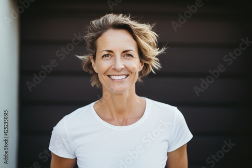 Smiling happy middle aged Caucasian woman wearing a white t shirt outside