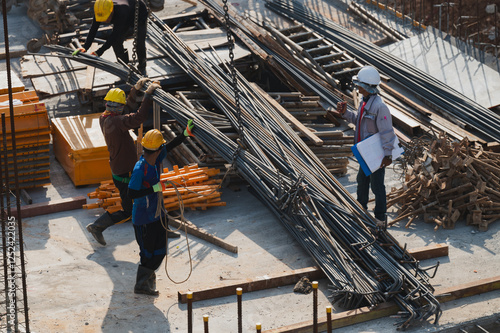 Принти на полотні Construction Workers Handling Steel Rebar, Workers are skillfully maneuvering st
