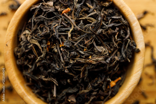 Japanese or Chinese jasmine tea leaf in wooden bowl on wooden background. photo