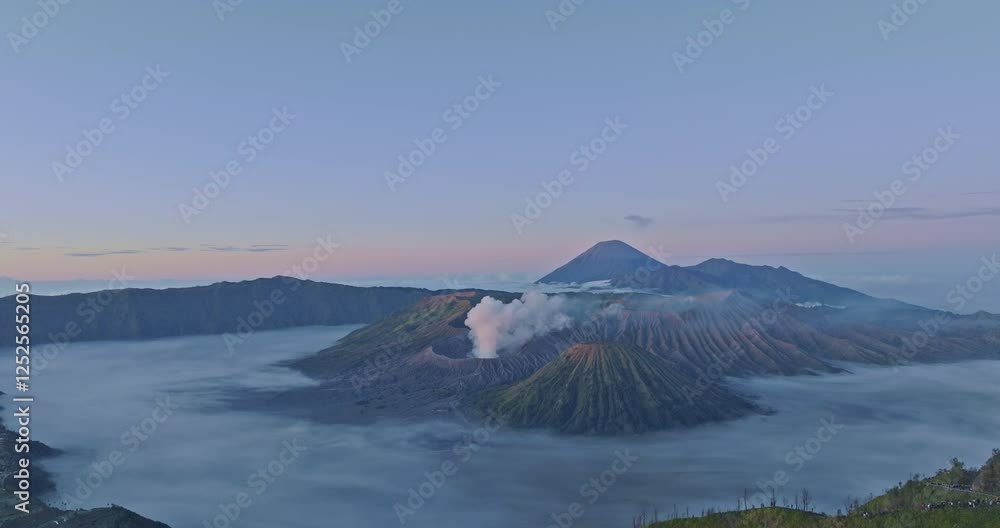 aerial view of breathtaking Mount Bromo surrounded by mist and dramatic landscapes. an active volcano in Indonesia, The soft morning light highlights the rugged terrain and the rising volcanic smoke aerial view of breathtaking Mount Bromo surrounded by mist and dramatic landscapes. an active volcano in Indonesia, The soft morning light highlights the rugged terrain and the rising volcanic smoke