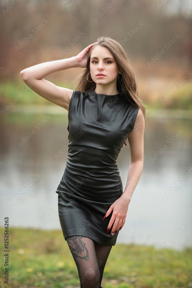 Portrait of a young beautiful brown-eyed long-haired girl in a black dress in nature. Portrait of a young beautiful brown-eyed long-haired girl in a black dress in nature.