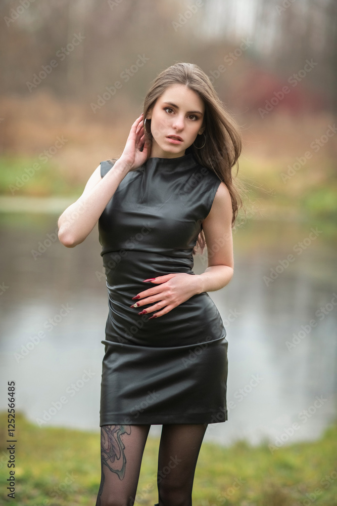 Portrait of a young beautiful brown-eyed long-haired girl in a black dress in nature. Portrait of a young beautiful brown-eyed long-haired girl in a black dress in nature.