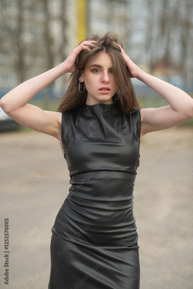 Portrait of a young beautiful brown-eyed long-haired girl in a black dress in nature. Portrait of a young beautiful brown-eyed long-haired girl in a black dress in nature.
