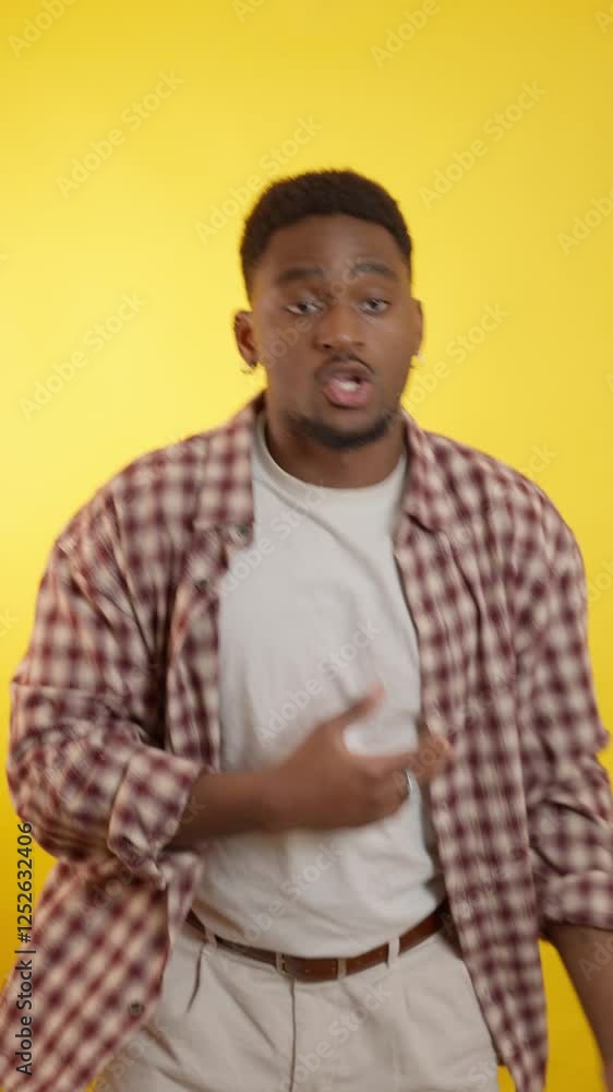 Young stylish man dancing on yellow background Young stylish man dancing on yellow background