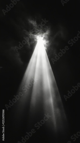 Light beam breaking through darkness illuminating particles in the air