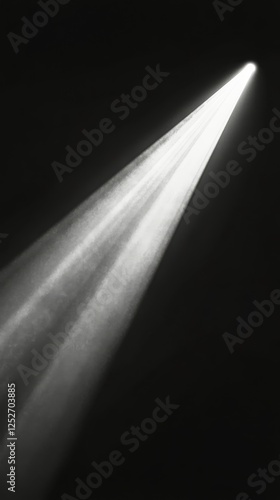 Light beam breaking through darkness illuminating particles in the air