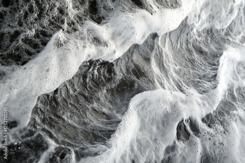 Surging wave curled over with dramatic texture in black and white photography