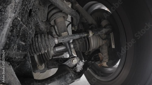 The operation of the car suspension in motion. Camera at the bottom of the car. The car is driving in the snow