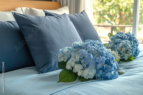 Blue hydrangea bouquets arranged on a bed with navy blue pillows in a serene ...
