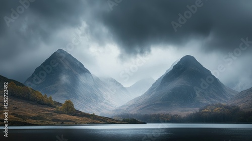 A dramatic view of mountains shrouded in mist with a dark moody sky. photo