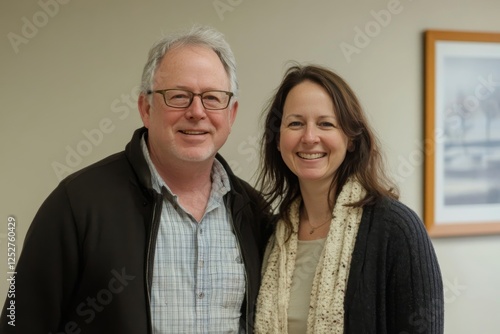 Portrait of a smiling woman and man indoors at a modern setting, showcasing f...
