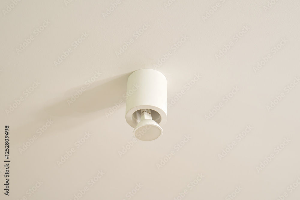 White ceiling light fixture mounted on a plain surface. Home lighting and interior design concept. White ceiling light fixture mounted on a plain surface. Home lighting and interior design concept.
