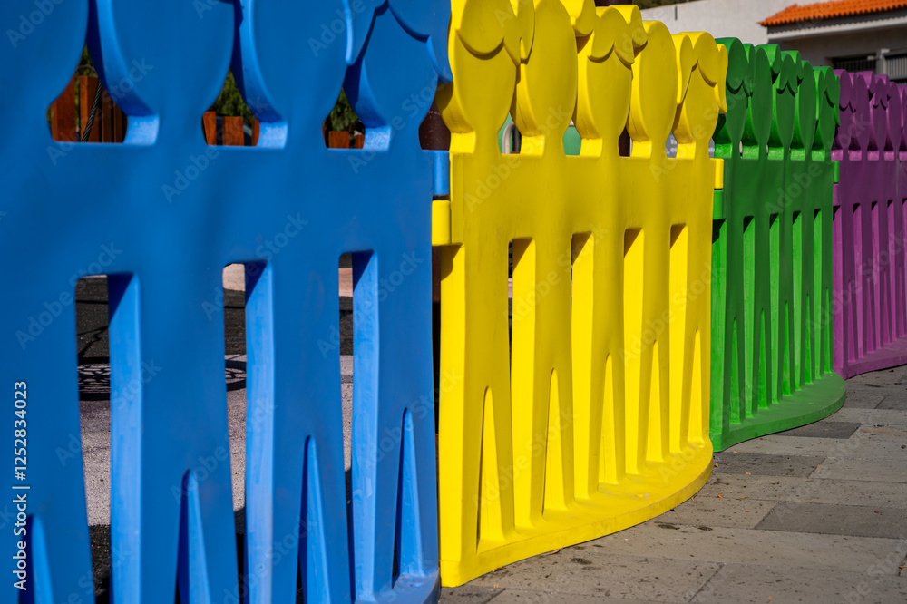 Fototapeta premium A row of colorful plastic figures are lined up in a row. The figures are of different colors and sizes, and they are all facing the same direction. Concept of unity and togetherness