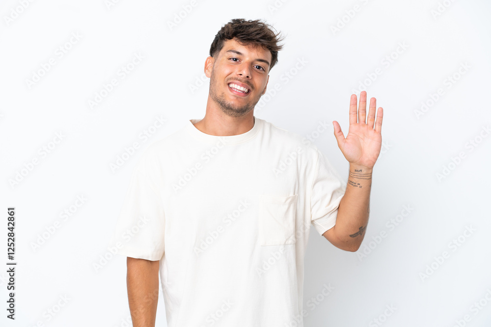 Young caucasian handsome man isolated on white background saluting with hand with happy expression Young caucasian handsome man isolated on white background saluting with hand with happy expression