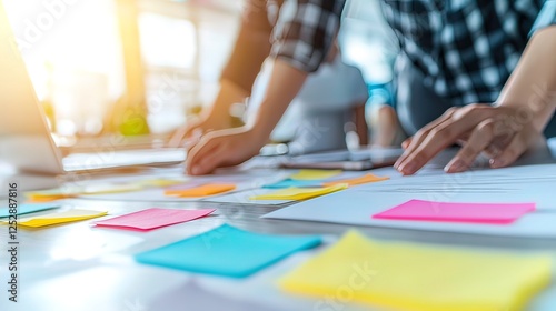 Close-up of diverse group of people collaborating and brainstorming ideas at a modern office. Sticky notes used for project planning. Teamwork, business planning, and creative ideas are in process..