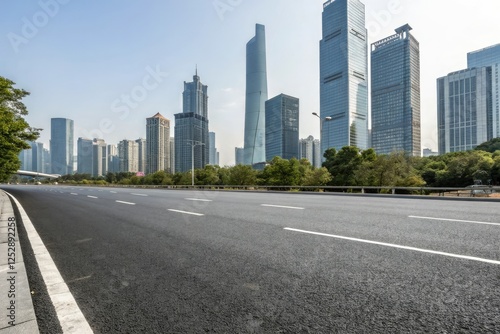 Wide asphalt road stretching through a modern cityscape with sleek skyscrapers and glass towers in the background, modern city, cityscape