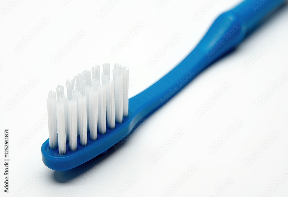 Blue Toothbrush Against White Background: A Simple Yet Effective Cleaning Tool. A blue toothbrush with white bristles on a white background. Blue Toothbrush Against White Background: A Simple Yet Effective Cleaning Tool. A blue toothbrush with white bristles on a white background.