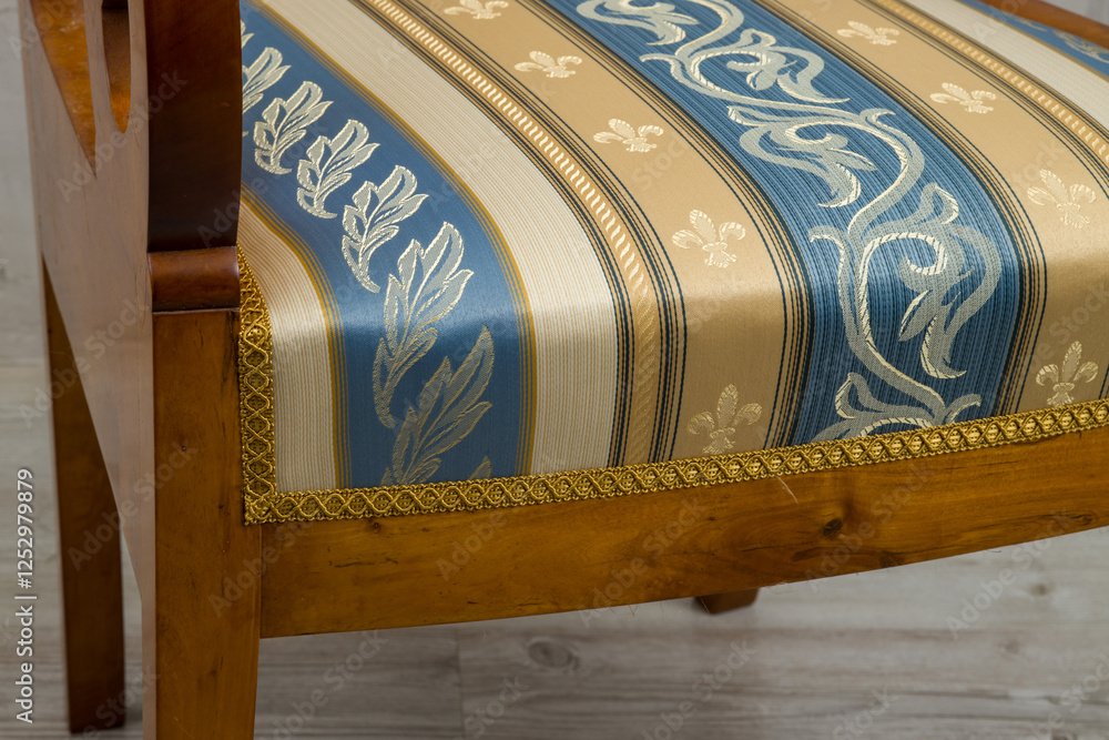 Biedermeier-style armchair in a room setting with a textured wall and wooden floor.