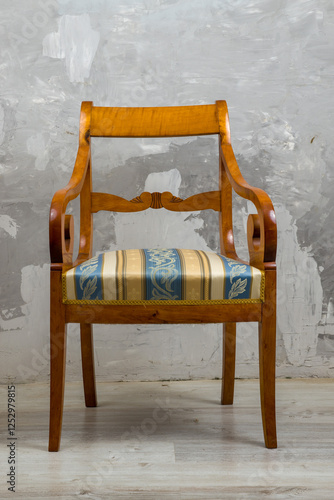 Obraz na płótnie Biedermeier-style armchair in a room setting with a textured wall and wooden floor. w salonie