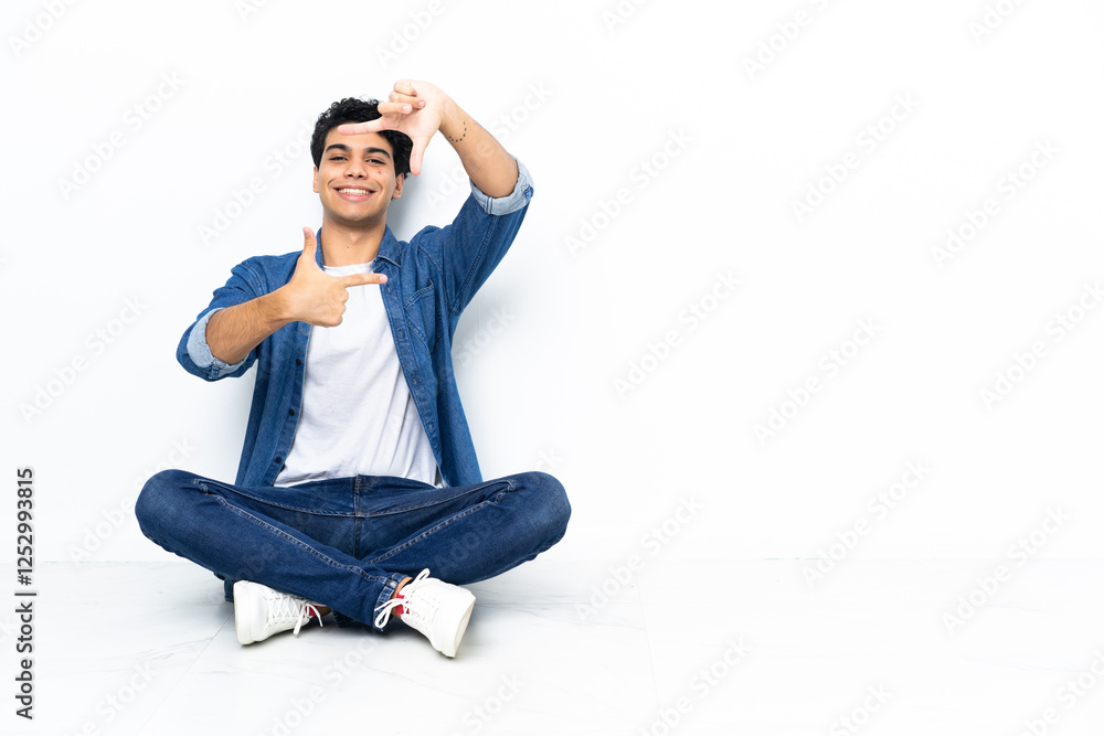 Venezuelan man sitting on the floor focusing face. Framing symbol Venezuelan man sitting on the floor focusing face. Framing symbol