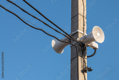 A Loudspeaker On A Pole With Wires On A Sunny Day