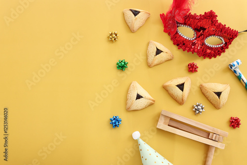 Purim celebration concept (jewish carnival holiday) over yellow background photo