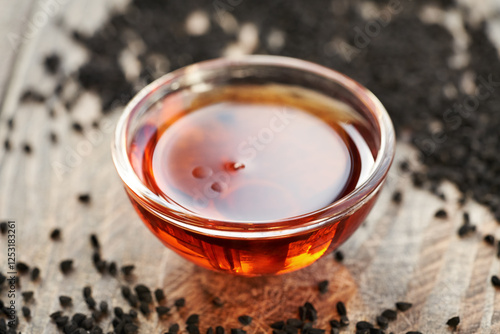 A bowl of black cumin or Nigella sativa seed oil photo