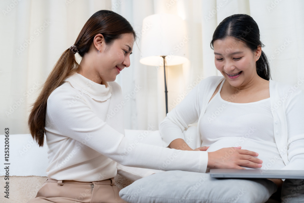Beautiful pregnant Asian woman nearing birth. Friend touching belly, smiling warmly, sharing affectionate moment. Happiness, deep connection, and love for unborn baby in cozy home setting. Beautiful pregnant Asian woman nearing birth. Friend touching belly, smiling warmly, sharing affectionate moment. Happiness, deep connection, and love for unborn baby in cozy home setting.