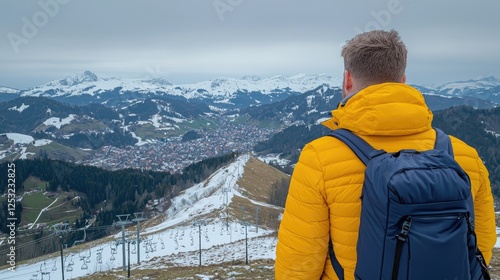Hiker contemplates snowy mountain valley vista