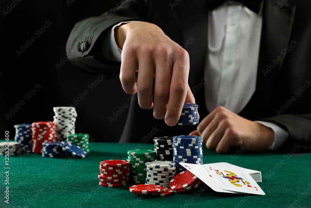 Man with cards and casino chips playing poker at gambling table, closeup Man with cards and casino chips playing poker at gambling table, closeup