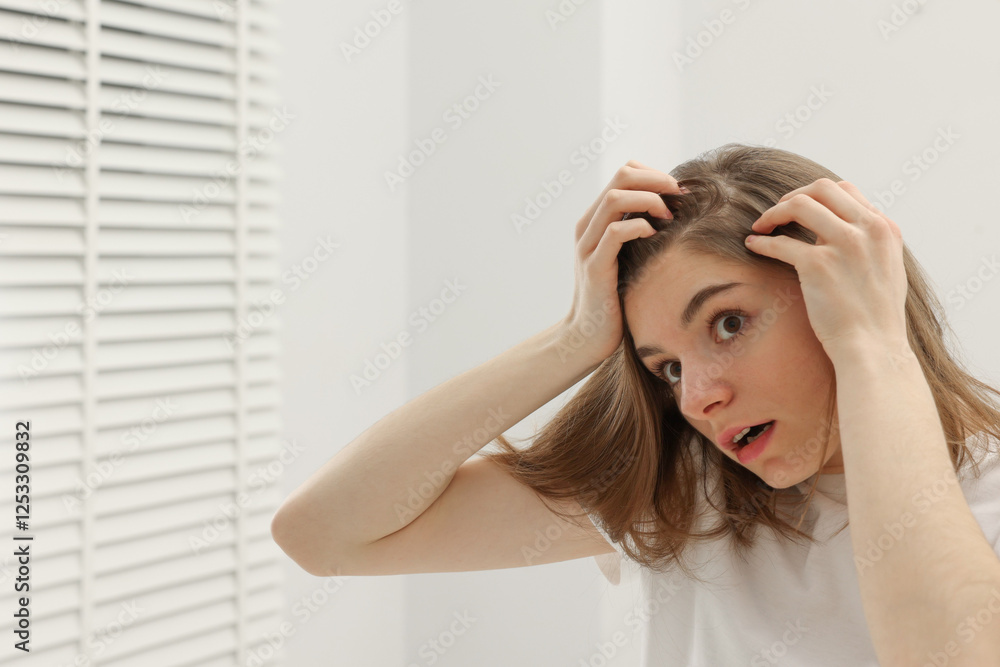 Girl with hair loss problem near mirror in bathroom, space for text Girl with hair loss problem near mirror in bathroom, space for text