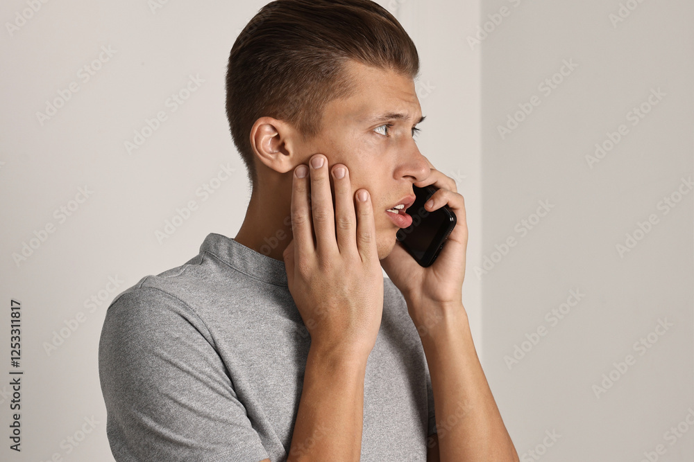 Stressed man calling hotline for mental health help indoors Stressed man calling hotline for mental health help indoors