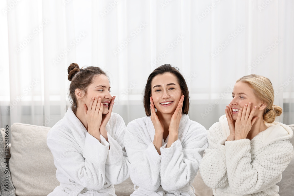 Happy woman wearing bathrobes on sofa in spa Happy woman wearing bathrobes on sofa in spa