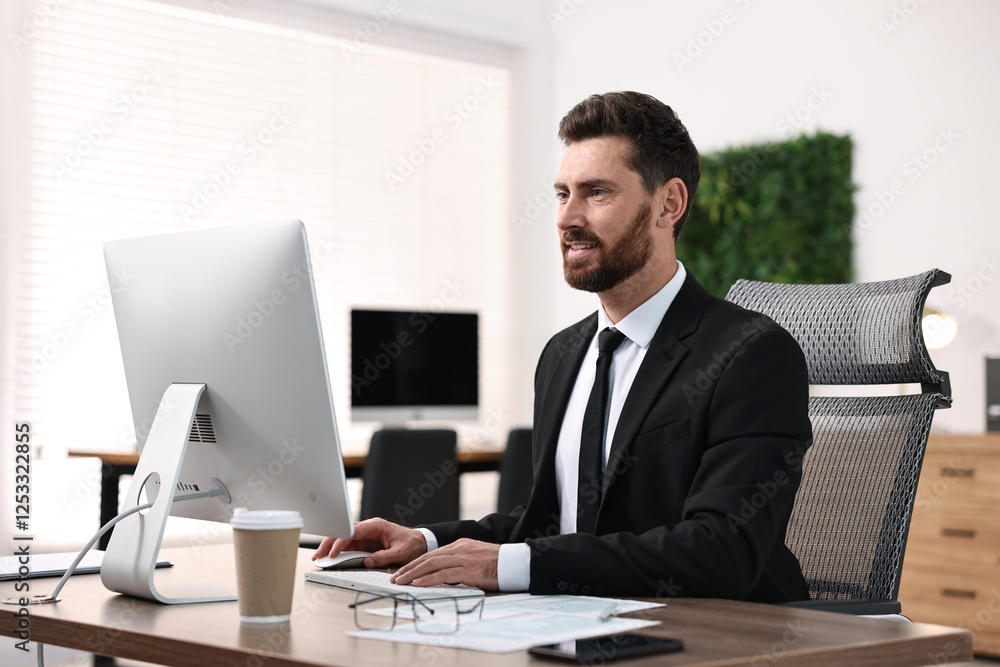 Man working on computer at table in office Man working on computer at table in office