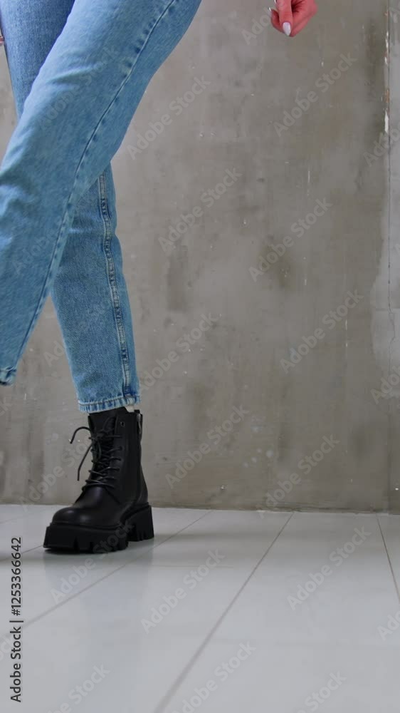 Stylish black leather low boots with laces on a lady. Close up. Model wearing jeans walks by the studio showing her modern footwear. Vertical video Stylish black leather low boots with laces on a lady. Close up. Model wearing jeans walks by the studio showing her modern footwear. Vertical video