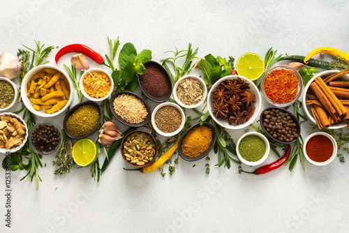 A collection of various spices and herbs on a gray background, perfect for enhancing dishes with rich flavors and textures