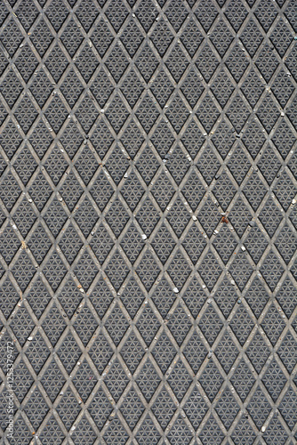 A close-up shot of a textured rubber surface with a repeating diamond plate pattern