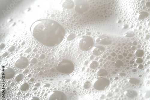 Bubbles on a white background, macro photography of water drops and bubbles on the surface of milk or shampoo foam texture. Close-up view with a focus effect
