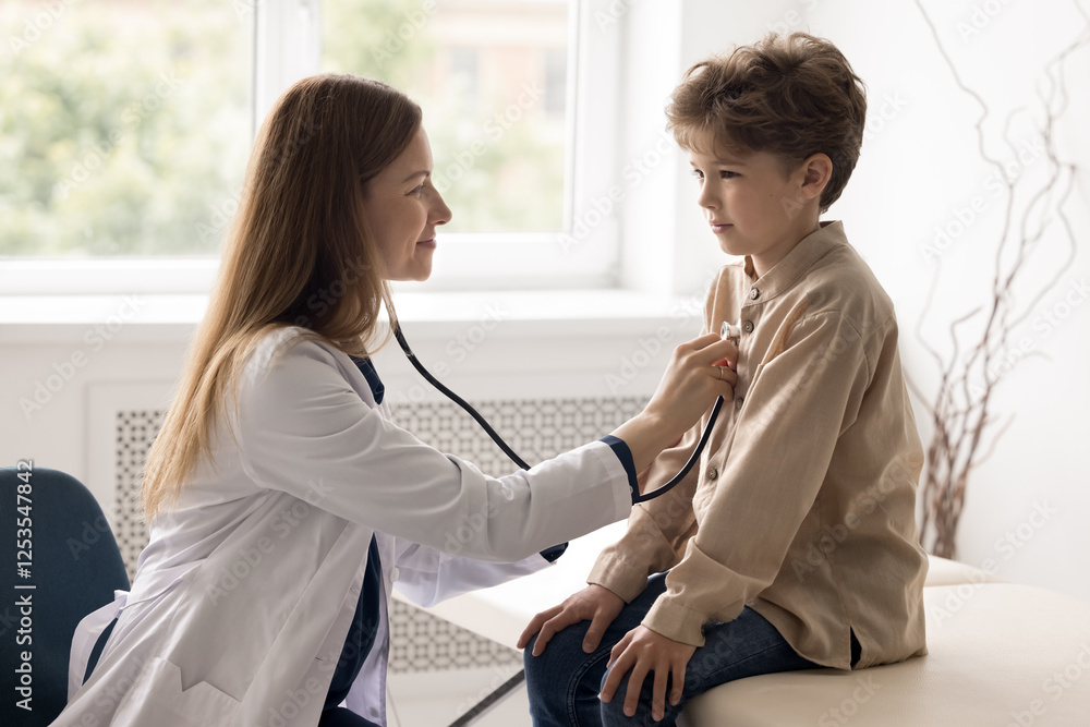 Fototapeta premium Timely screening examination. Professional female doctor pediatrician cardiologist checking up school age child patient health during regular meeting visit listen to heart beat rate using stethoscope