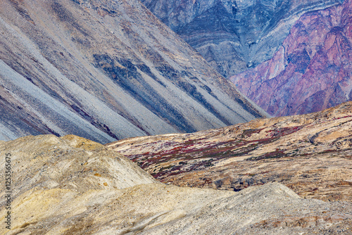 Geological layers above Hisinger Glacier, Dickson fjord, Northeast Greenland National Park. The moraine has deposited a mass of rocks and sediment within the colorful mountain peaks. photo