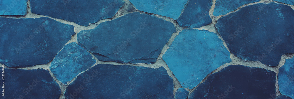 Deep indigo cement wall texture with rough details against a light blue background Deep indigo cement wall texture with rough details against a light blue background