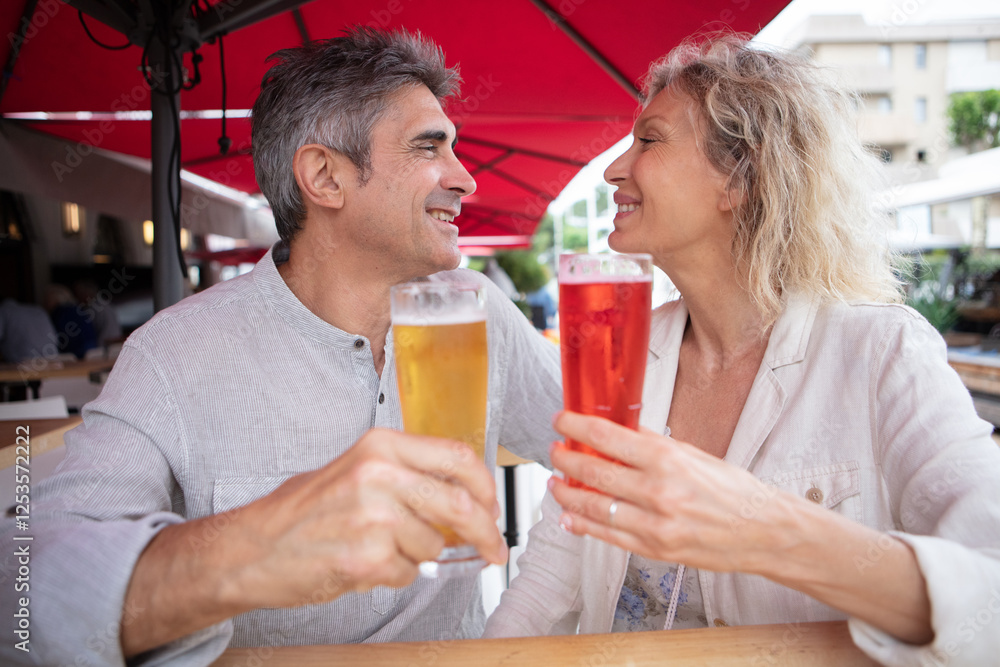 happy mature couple toasting each at an outdoor table happy mature couple toasting each at an outdoor table
