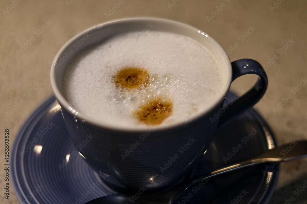 fresh cappuccino or coffee with milk in a blue cup and teaspoon fresh cappuccino or coffee with milk in a blue cup and teaspoon