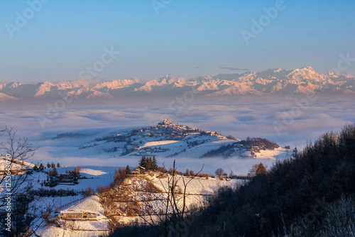 wine yards unique landscape winter sunset,medieval village castle on hill top, the Alps snow capped mountains background, italian heritage grape agriculture photo