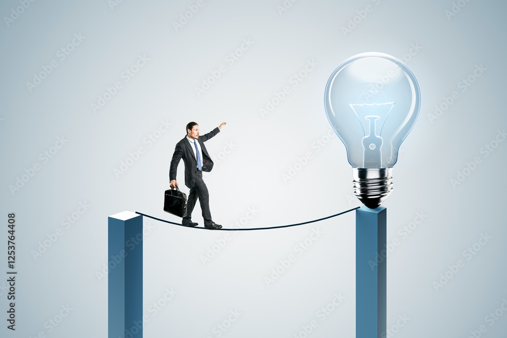 Businessman balancing on a rope towards a glowing lightbulb. Businessman balancing on a rope towards a glowing lightbulb.