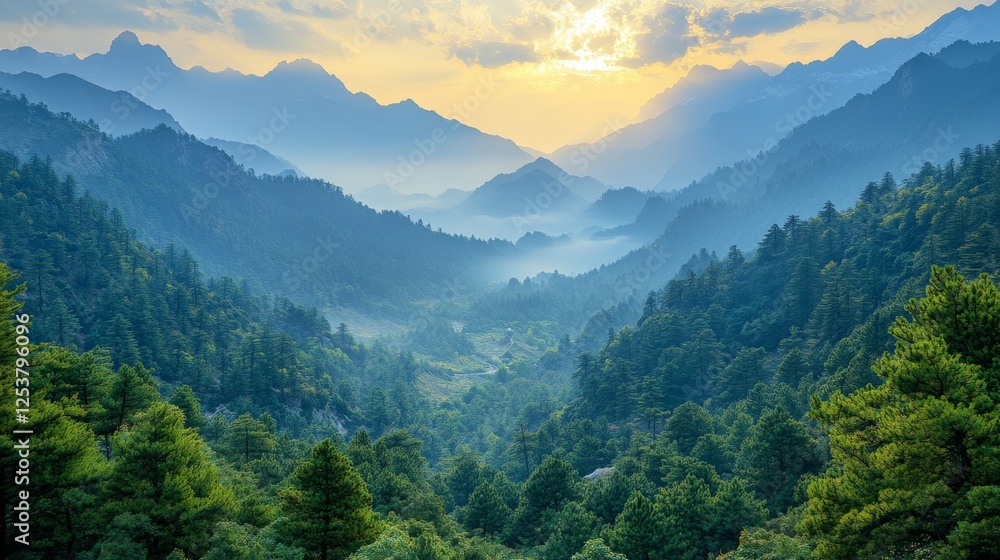 Obraz premium Serene Mountain Vista: Layers of Blue-Tinted Peaks, Green Forests, and a Radiant Sun Bursting Through the Clouds in a Breathtaking Landscape.