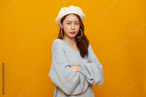 asian teen woman sulking and frowning disappointed, standing upset and distressed against isolated on yellow background.