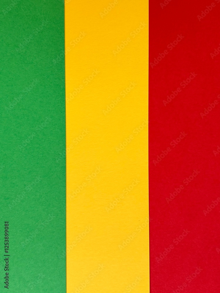 Fototapeta premium A bold and colorful abstract arrangement of green, yellow, and red paper strips forming a vertical striped pattern.