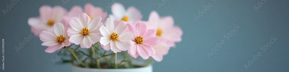 A white vase filled with fresh pink flowers A white vase filled with fresh pink flowers